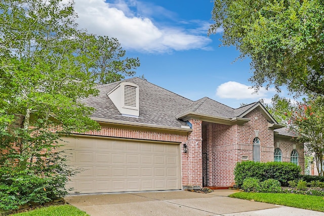 view of front of house with concrete driveway, brick siding, roof with shingles, and an attached garage