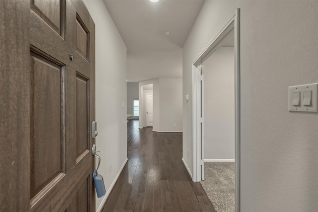 hall with dark wood-style floors and baseboards