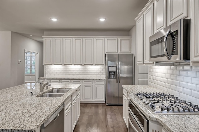 kitchen featuring stainless steel appliances, dark wood-type flooring, a sink, and white cabinetry