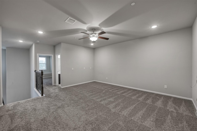 spare room with baseboards, visible vents, dark colored carpet, and recessed lighting