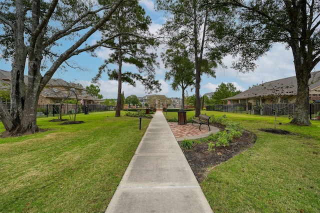 view of home's community featuring a lawn and fence