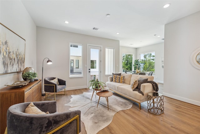 living room with baseboards, visible vents, wood finished floors, and recessed lighting