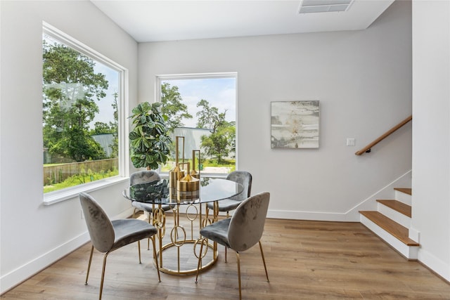 dining area featuring baseboards, plenty of natural light, visible vents, and wood finished floors