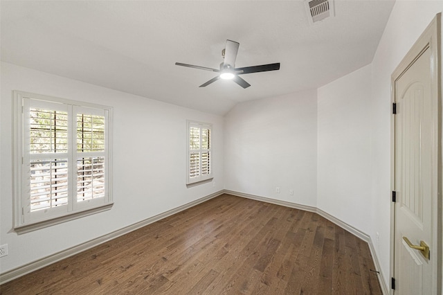 empty room featuring baseboards, visible vents, ceiling fan, wood finished floors, and vaulted ceiling