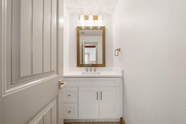 bathroom featuring a textured wall and vanity