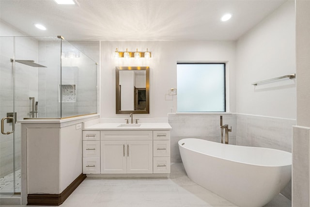 full bathroom featuring a stall shower, a freestanding tub, vanity, and recessed lighting