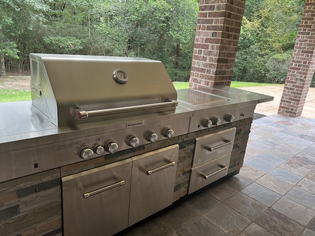 view of patio featuring a wooded view and an outdoor kitchen