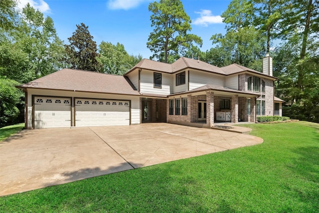 view of front of house with an attached garage, brick siding, concrete driveway, a chimney, and a front yard