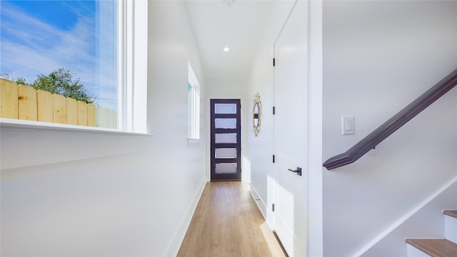 hallway with baseboards, stairway, light wood-style flooring, and recessed lighting