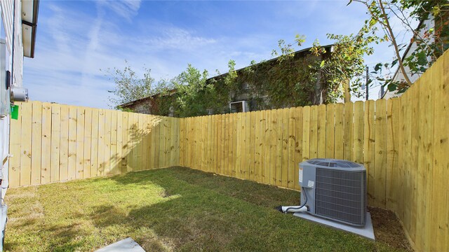 view of yard featuring a fenced backyard and central AC