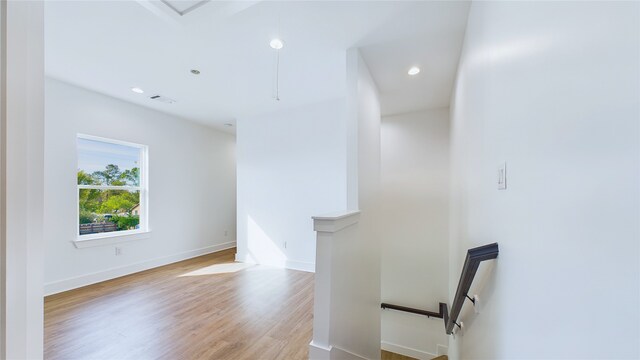 interior space with visible vents, baseboards, an upstairs landing, recessed lighting, and light wood-style flooring