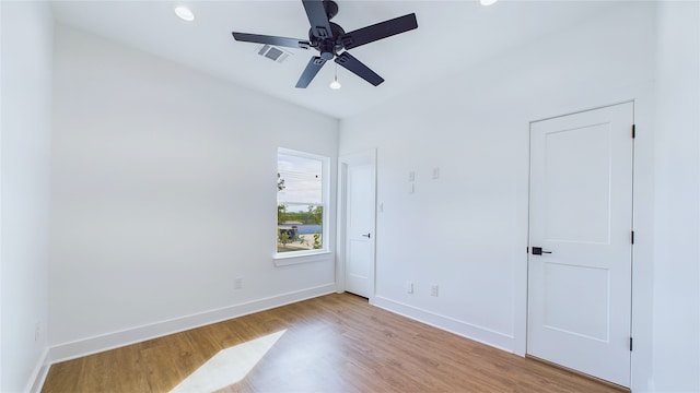 unfurnished bedroom with a ceiling fan, wood finished floors, visible vents, and baseboards