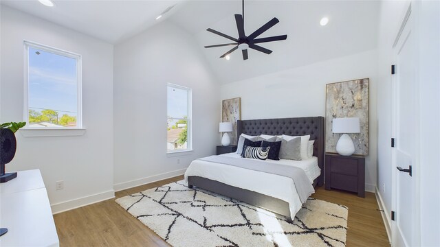 bedroom with baseboards, multiple windows, and wood finished floors