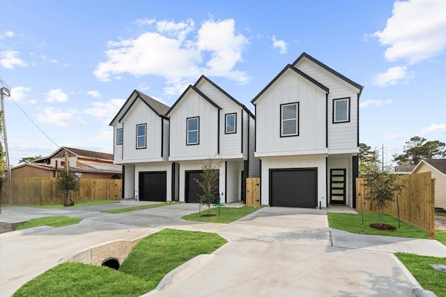 view of front facade featuring board and batten siding, fence, driveway, and a garage