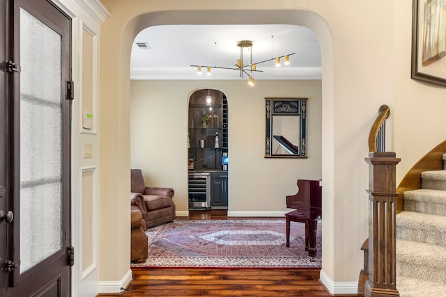 foyer with visible vents, arched walkways, wine cooler, dark wood-type flooring, and stairs