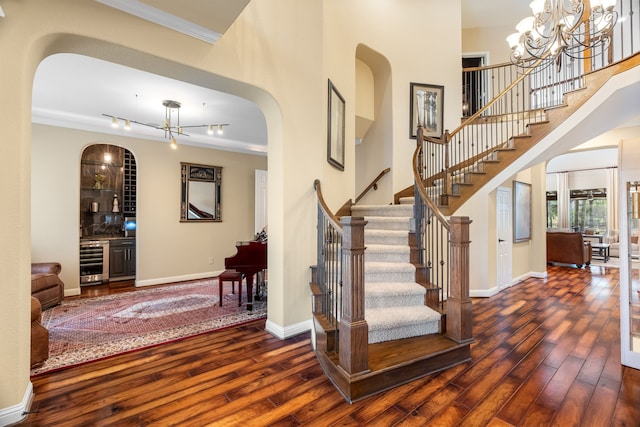 foyer featuring ornamental molding, wine cooler, baseboards, and hardwood / wood-style flooring