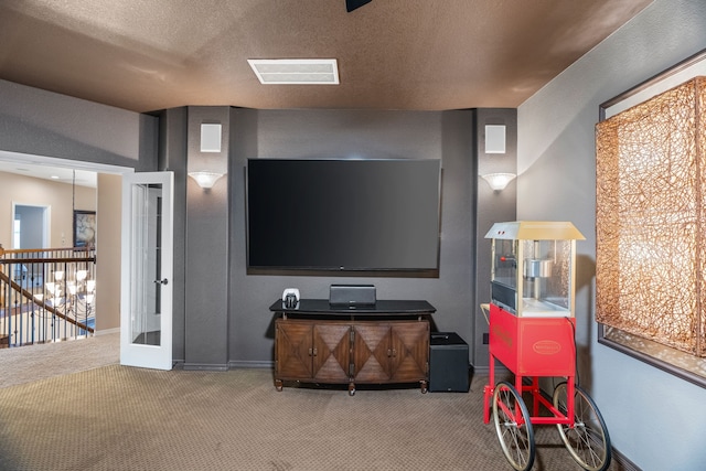 cinema room with baseboards, visible vents, a textured ceiling, french doors, and carpet floors