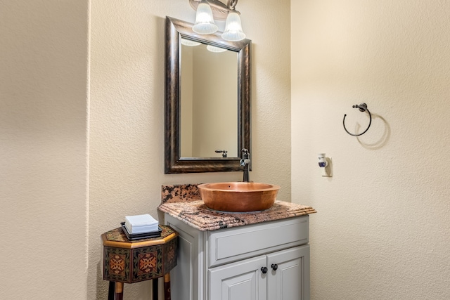 bathroom with a textured wall and vanity