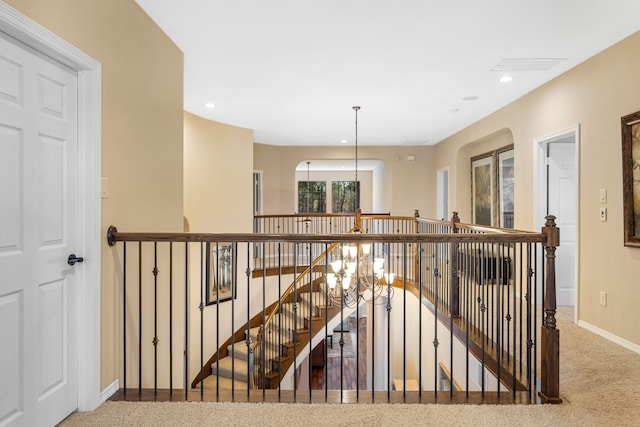 corridor featuring recessed lighting, an inviting chandelier, an upstairs landing, and baseboards