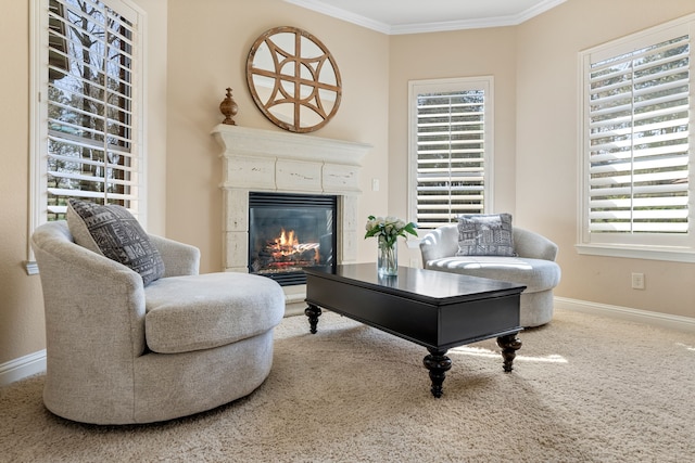 sitting room with carpet floors, baseboards, ornamental molding, and a glass covered fireplace