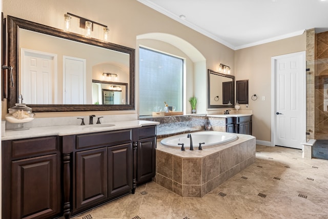 bathroom with two vanities, a sink, ornamental molding, a tile shower, and a bath