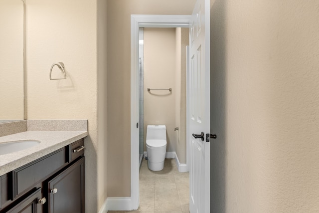 bathroom featuring baseboards, vanity, toilet, and tile patterned floors