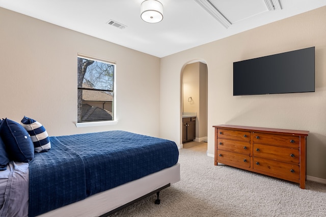 bedroom with carpet floors, baseboards, visible vents, and arched walkways