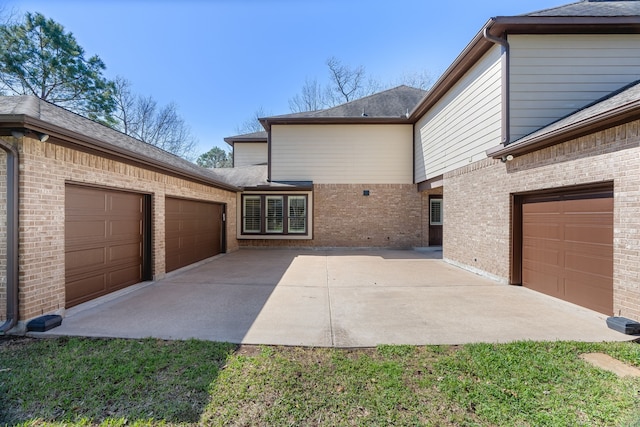 view of side of property featuring a garage and brick siding