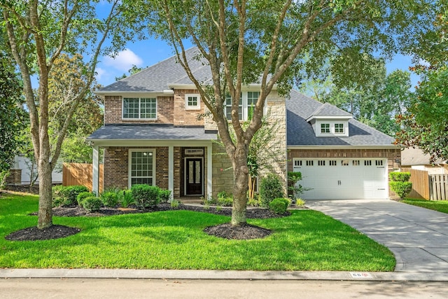 view of front of house with a shingled roof, an attached garage, fence, and a front yard