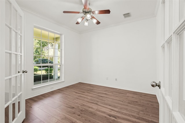 unfurnished room with ornamental molding, visible vents, baseboards, and wood finished floors