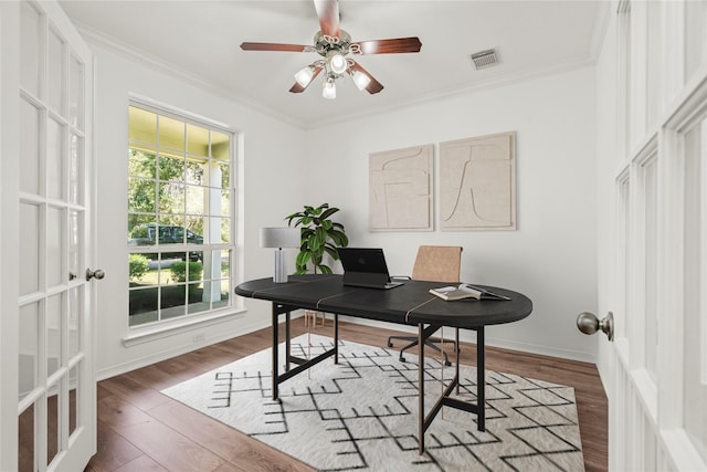 office space with baseboards, visible vents, ornamental molding, and wood finished floors