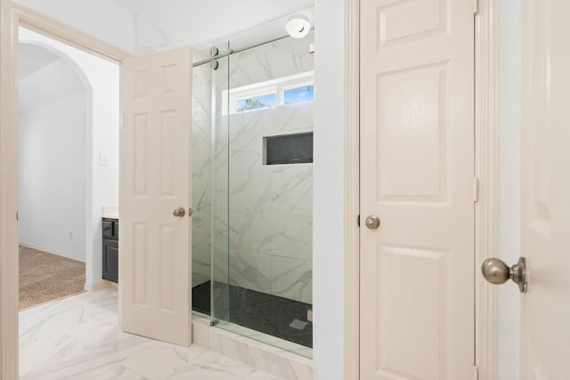 full bathroom featuring marble finish floor, a marble finish shower, and vanity