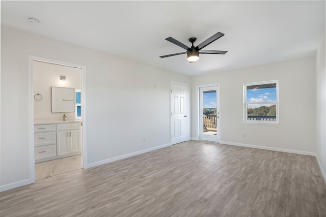 unfurnished bedroom featuring access to outside, a sink, and baseboards