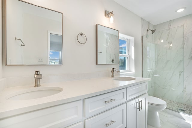 full bathroom featuring toilet, marble finish floor, a marble finish shower, and a sink