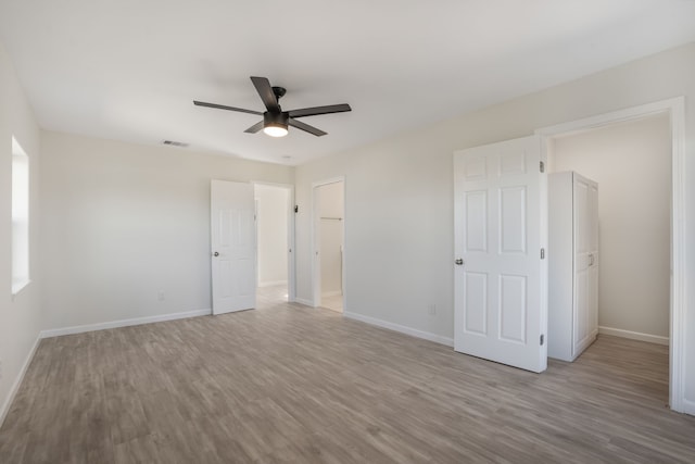 unfurnished bedroom with baseboards, visible vents, and wood finished floors