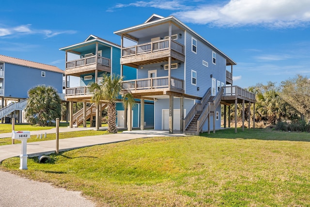 exterior space featuring concrete driveway, a front lawn, stairway, and an attached garage