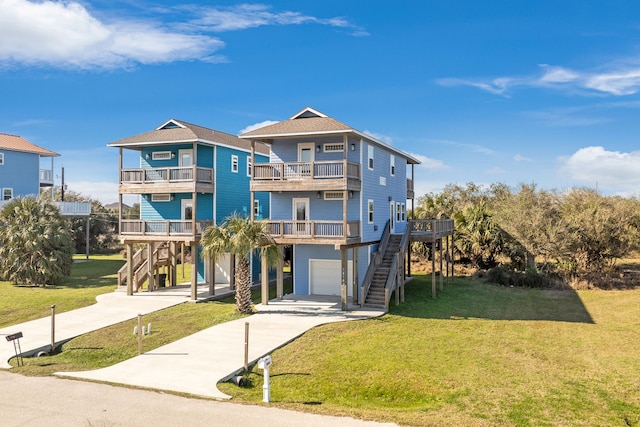 raised beach house featuring a garage, stairs, driveway, a carport, and a front lawn