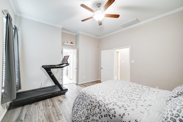 bedroom featuring crown molding, light wood finished floors, visible vents, attic access, and baseboards