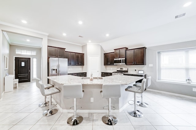 kitchen with a large island, visible vents, appliances with stainless steel finishes, light tile patterned flooring, and a kitchen bar