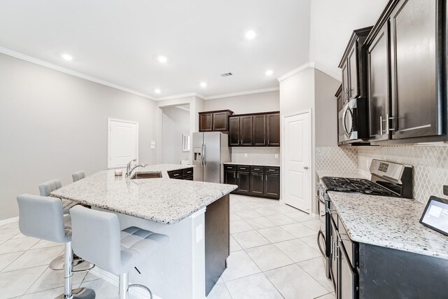 kitchen with visible vents, appliances with stainless steel finishes, light tile patterned flooring, and a large island with sink