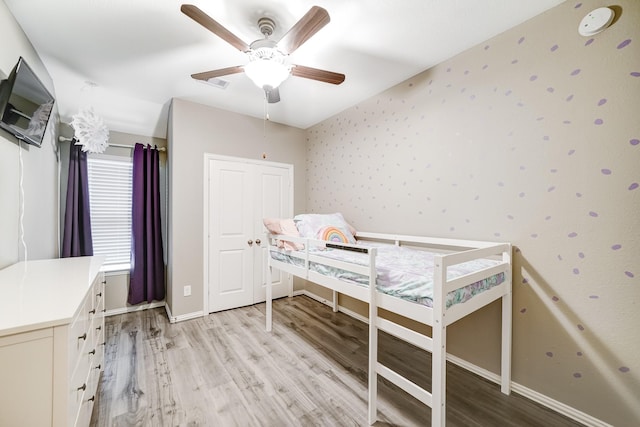 bedroom featuring wallpapered walls, baseboards, light wood finished floors, and a ceiling fan