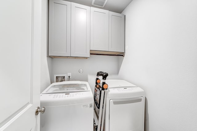 clothes washing area featuring cabinet space, visible vents, and separate washer and dryer