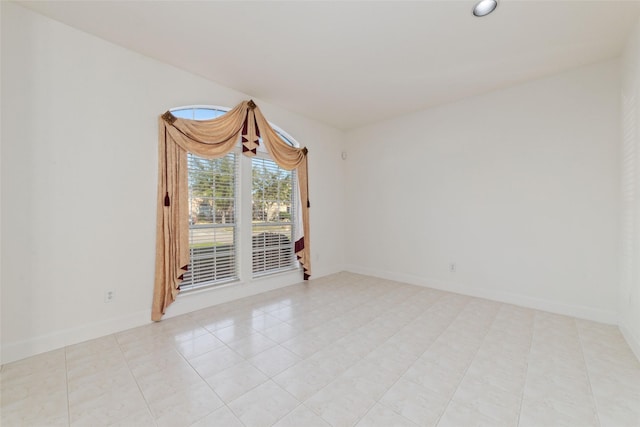 unfurnished room featuring light tile patterned floors and baseboards