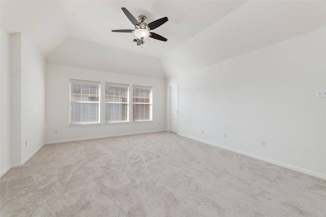 empty room featuring ceiling fan, carpet, baseboards, and vaulted ceiling