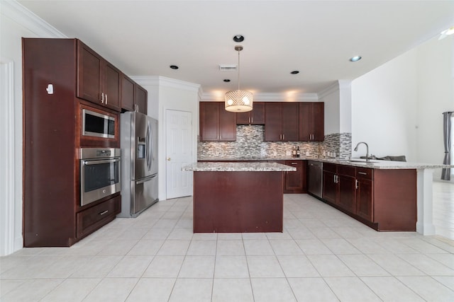 kitchen featuring a peninsula, appliances with stainless steel finishes, a center island, and tasteful backsplash