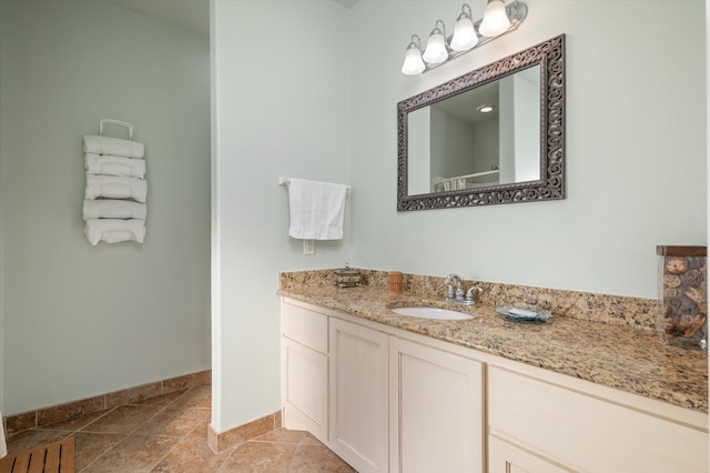 full bath with tile patterned flooring, vanity, and baseboards