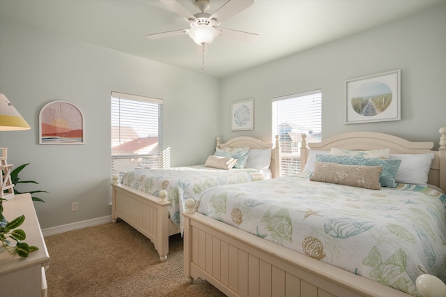 bedroom featuring ceiling fan, multiple windows, baseboards, and light colored carpet