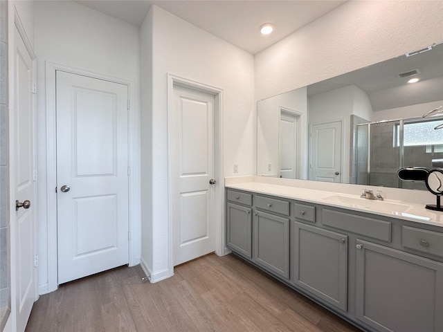 full bath featuring visible vents, wood finished floors, vanity, a shower stall, and recessed lighting