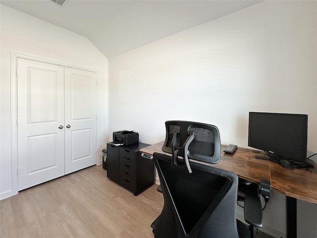 office area featuring light wood finished floors and vaulted ceiling