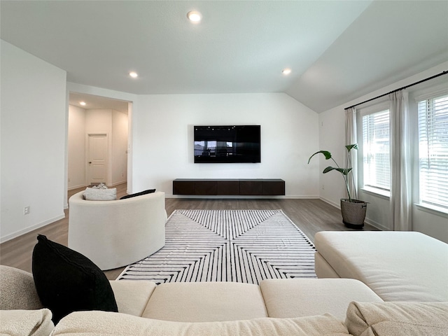 living area featuring lofted ceiling, baseboards, recessed lighting, and wood finished floors